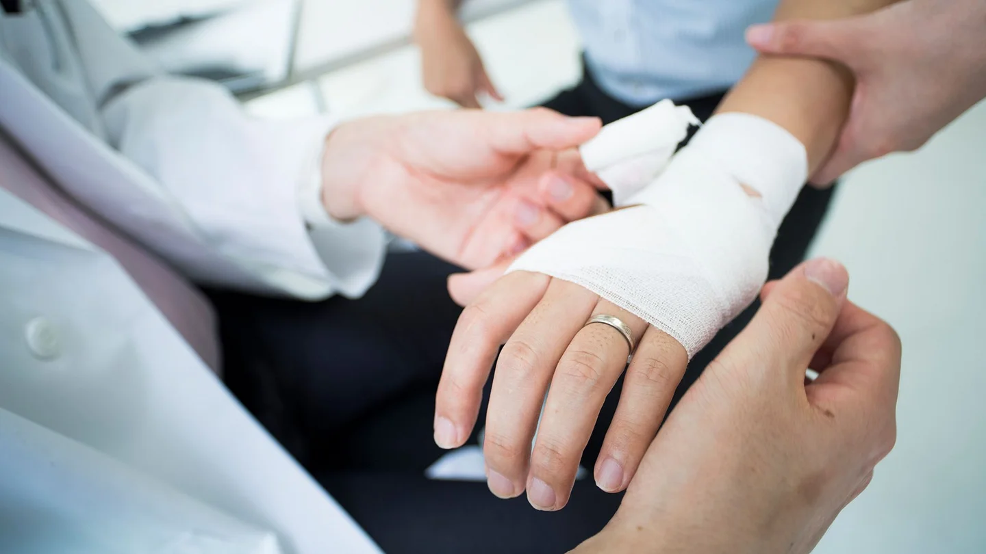 Erysipel: Ein Mann erhält einen Verband ums Handgelenk.