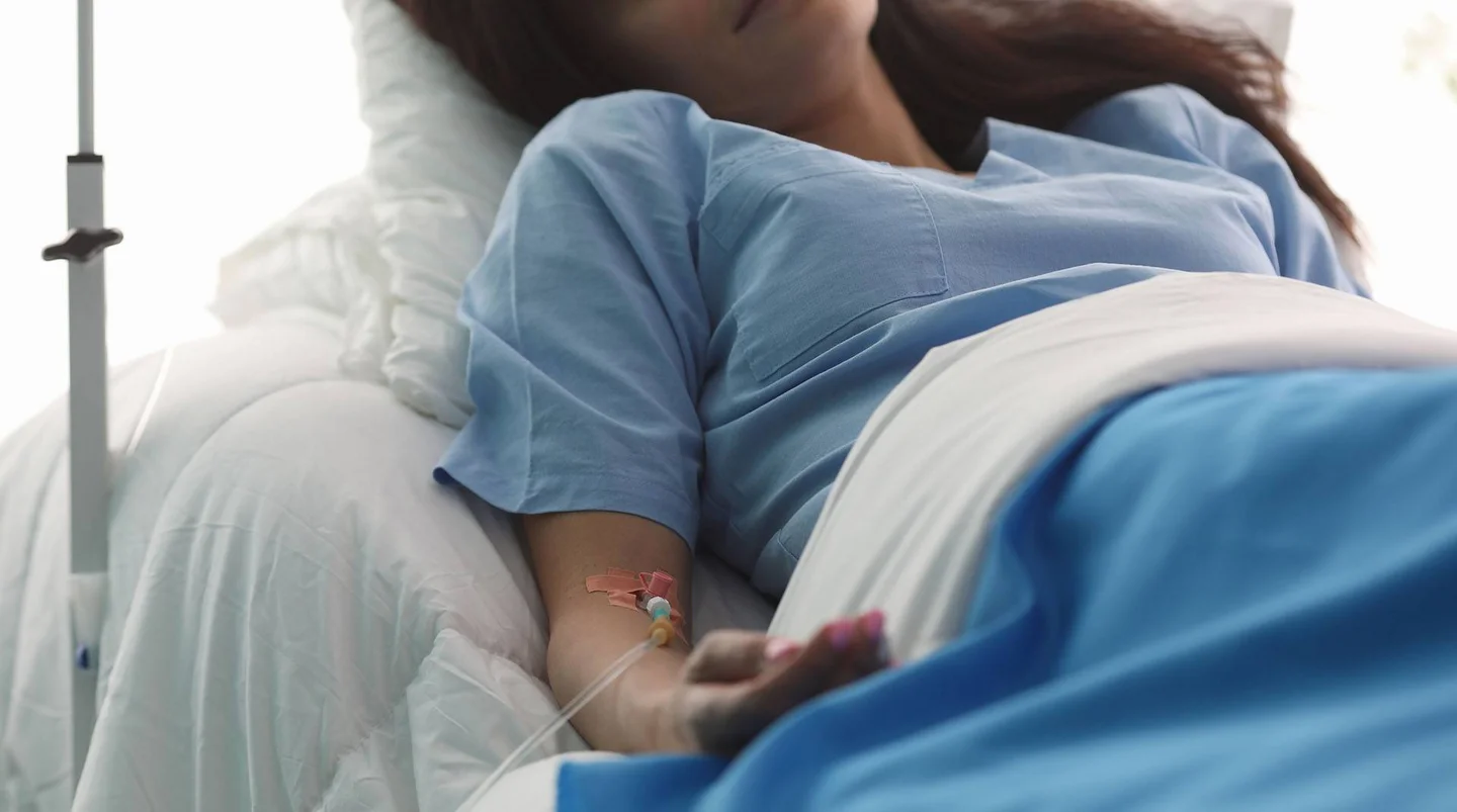 Frau mit Infusion im Krankenbett