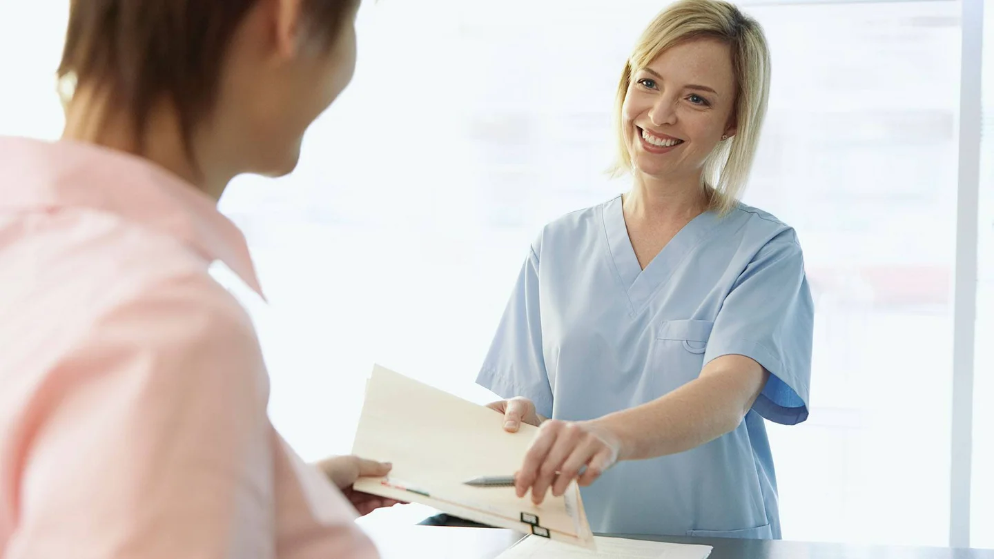 Eine Frau &uuml;bergibt einer anderen ein Dokument