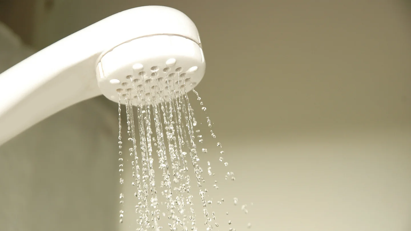 Ein Duschkopf mit fallenden Wassertropfen.