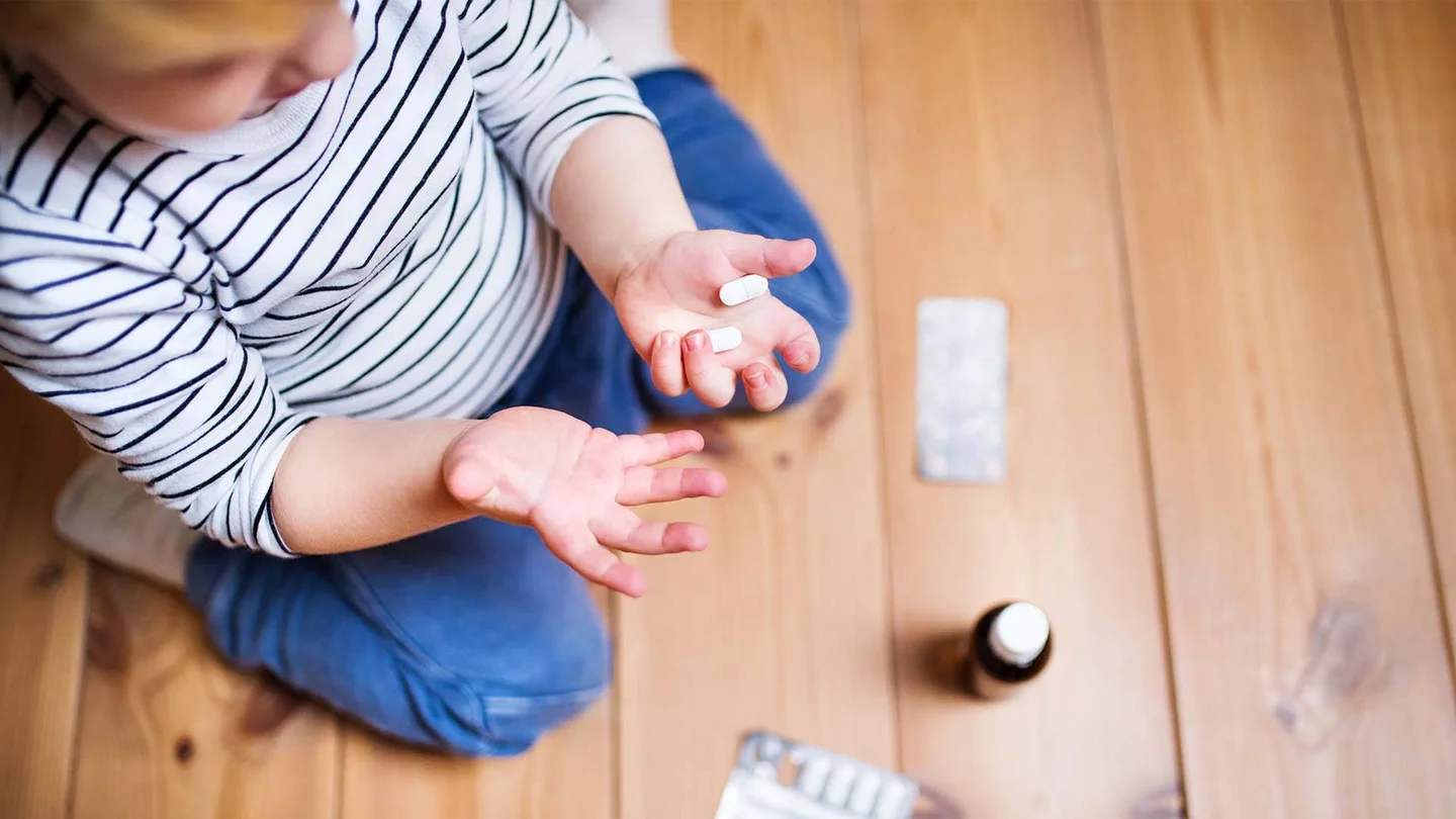 Kind spielt mit Medikamenten