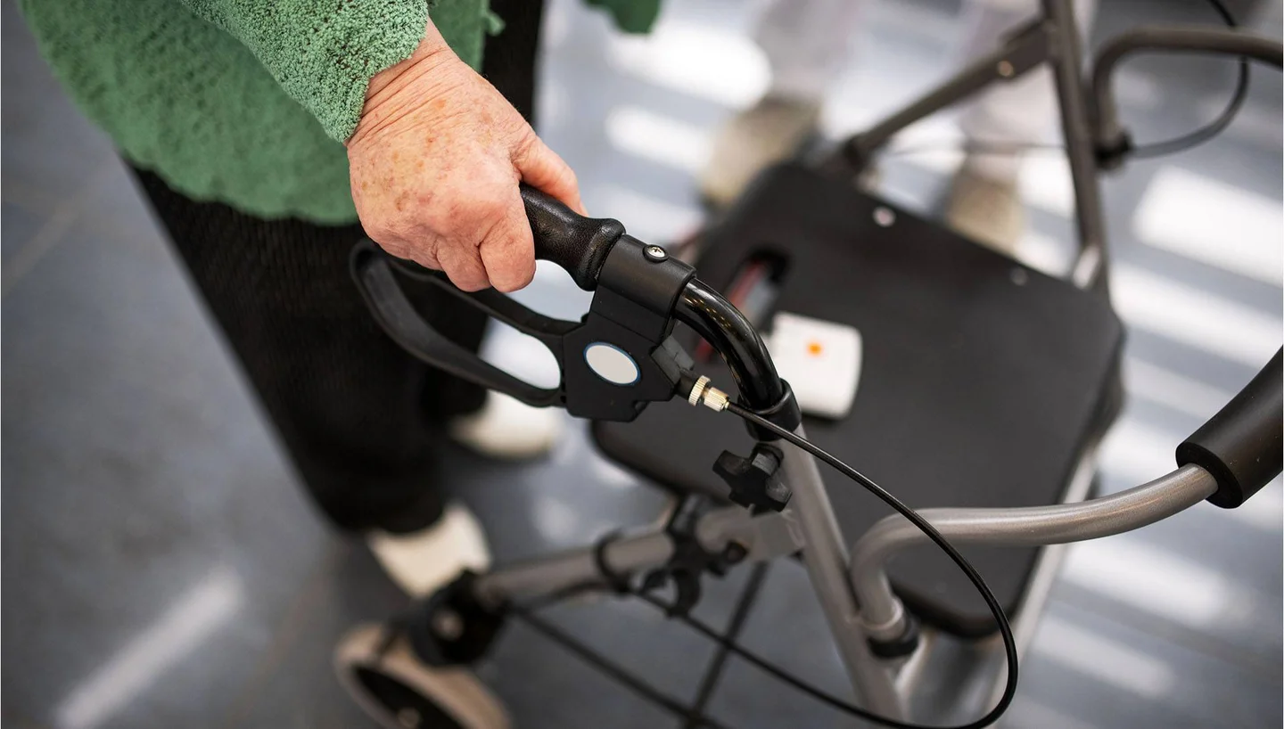 Eine Frau schiebt eine Gehhilfe