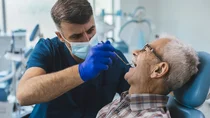 &Auml;lterer Mann wird vom Zahnarzt untersucht.